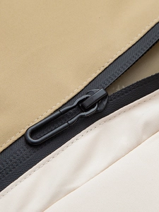 Detailaufnahme des wasserdichten Reißverschlusses an einer khakifarbenen Outdoor-Windjacke