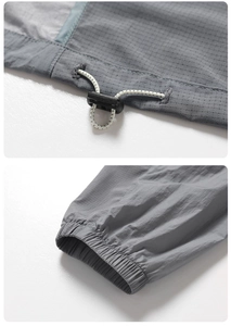 Detailed view of adjustable drawstring and elastic cuff on grey sun protection jacket