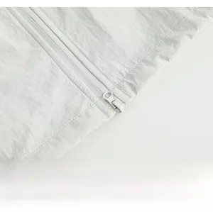 Detail of zipper closure and ripstop texture on white hooded UV protection jacket