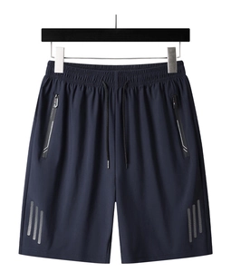 Dettaglio dei pantaloncini sportivi con tasche a cerniera e strisce catarifrangenti