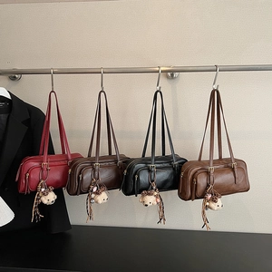 Detail showing four vintage underarm bags with plush bear charms in various colors