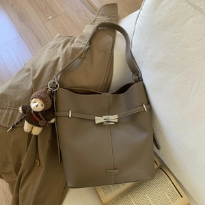 Close-up of khaki bucket bag with lychee grain leather and cute teddy bear charm