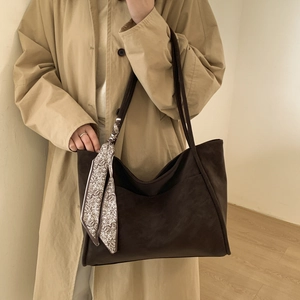 Detail of dark brown leather tote bag featuring a vintage printed silk scarf decoration