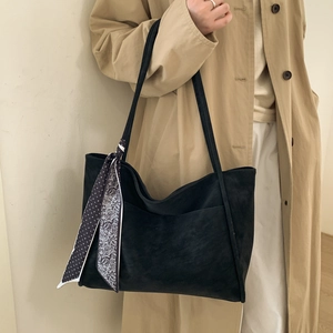 Detail of black suede tote bag with printed silk scarf and slim shoulder straps