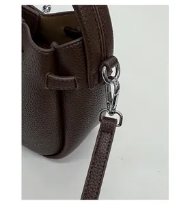 Detail of silver hardware and litchi texture on dark brown leather bucket bag