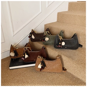 Close-up of minimalist hobo bags in assorted colors with retro beaded charm detail