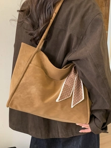 Brown large capacity tote bag with polka dot scarf shown on a model in profile