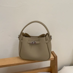 Close-up of khaki pebbled leather bucket bag with metallic twist lock and top handle