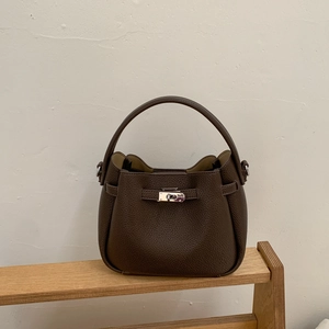 Close-up of dark coffee litchi grain leather bucket bag with silver metal twist lock