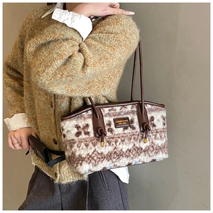 Close-up of fluffy faux fur tote bag with brown leather strap and gold logo detail