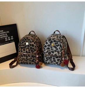 Close-up of leopard print plush backpacks with faux leather trim and tassel charms