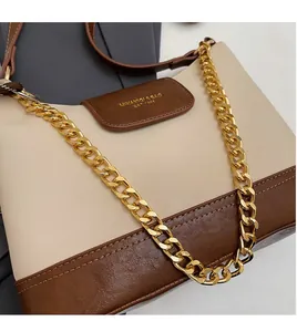 Detail of color-block shoulder bag with chunky gold chain and premium leather texture