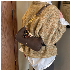 Detail of coffee brown moon bag with gold HC metal buckle and beaded charm accessory