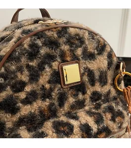 Detail of leopard print plush backpack showing gold hardware and leather trim