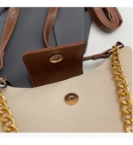 Detail of premium golden metal chain strap and magnetic buckle on the color-block bag