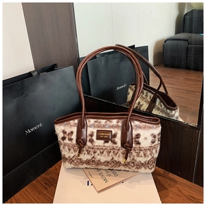 Close-up of plush tote bag texture with brown knit pattern and leather handles
