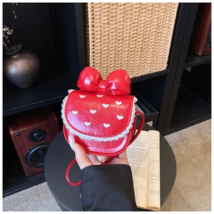 Detail of red PU leather children's handbag featuring a bow, lace trim, and heart embroidery