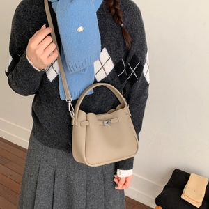 Chic beige lychee grain leather bucket bag with metal buckle and crossbody strap detail