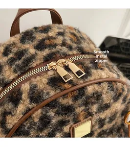 Detail of leopard print plush backpack with gold dual zippers and brown leather trim
