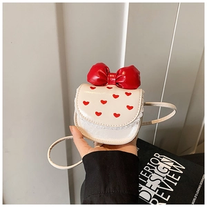 Close-up of children's mini crossbody bag with red bow, heart embroidery and lace trim