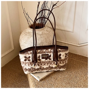 Macro detail of plush floral tote bag with brown leather strap and brand logo patch