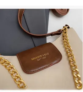 Detailed close-up of quilted contrast handbag with gold chain and logo engraving