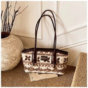 Close-up of retro floral plush fabric and brown leather handle on a large tote bag
