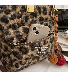 Close-up of leopard print furry backpack front pocket showing storage for a smartphone