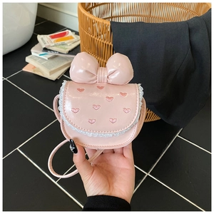 Detailed view of pink mini handbag featuring a large bow and sweet heart embroidery