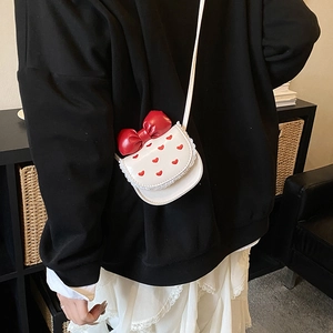 Detailed shot of white PU crossbody bag with red bow, heart embroidery and lace trim