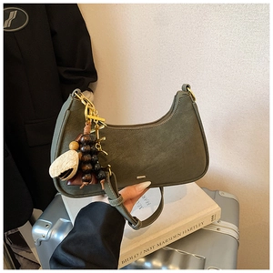 Detailed shot of dark olive green crescent bag with textured leather and gold hardware