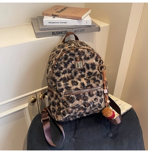 Detail of leopard print faux fur backpack with fluffy pom-pom charm and dual zipper