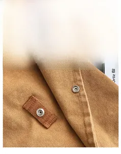 Detailed close-up of brown canvas fabric texture with silver snap buttons and stitching