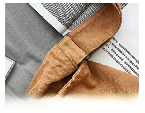 Detail of reinforced stitching on the canvas bag strap and black plastic buckle