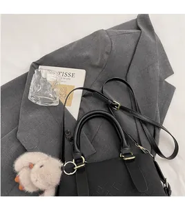 Detail of black woven leather handbag with gold hardware and plush rabbit charm