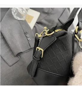 Detail of black woven texture on pillow bag with gold-tone metal hardware accents