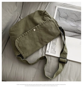 Detail of army green canvas messenger bag with metal buckle and adjustable strap