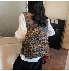 Close-up of leopard print faux fur backpack featuring plush texture and brown leather straps