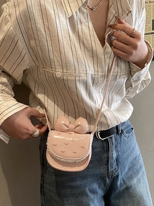 Pink heart-patterned mini crossbody bag with large bow and lace trim detail