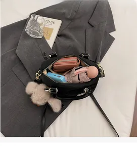 Interior view of black quilted shoulder bag with plush charm showing large capacity space