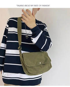 Urban army green canvas messenger bag with adjustable strap worn over a striped shirt