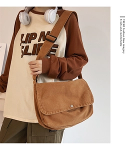 Close-up of brown canvas messenger bag with metal buckle and adjustable shoulder strap