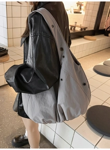Chic grey nylon hobo bag featuring silver eyelets on a model for daily casual wear