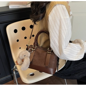 Detail der Webstruktur einer dunkelbraunen Boston Bag mit Plüschhasen-Anhänger