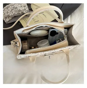 Internal view of beige square bag showing spacious capacity for phone and cosmetics