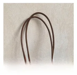 Detailed close-up of brown leather bucket bag handle with lychee texture and stitching