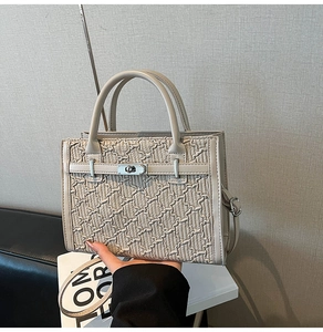 Detail of cream Kelly bag showing 3D quilted texture and silver metallic turn-lock closure