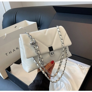 Detailansicht der weißen gesteppten Ledertasche mit Silberkette und Metallverschluss