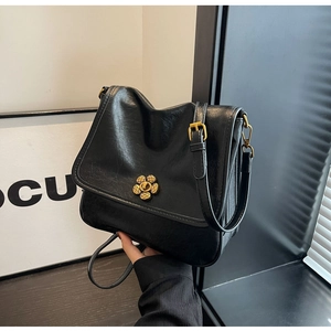 Detail of vintage black flap handbag with golden sunflower metallic rotating lock