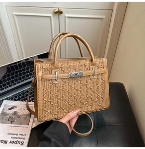 Detail of caramel leather handbag with wavy embossed texture and silver twist lock